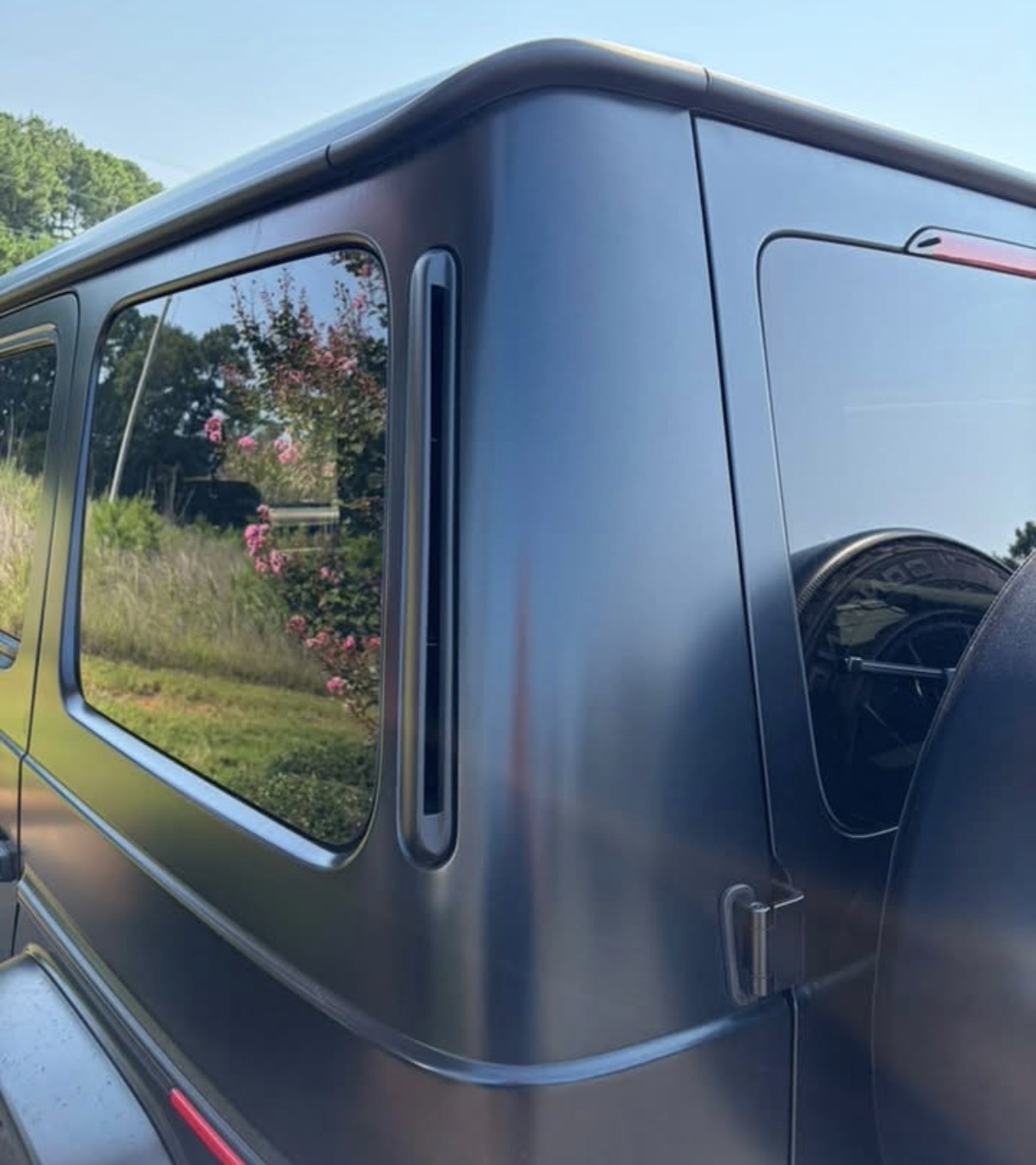 The same matte black quarter panel after paintless dent repair, crease removed and body line restored